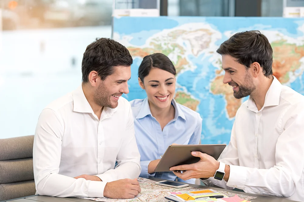 Frau in gestreiftem Blazer spricht engagiert mit Kollegin während einer Diskussion.